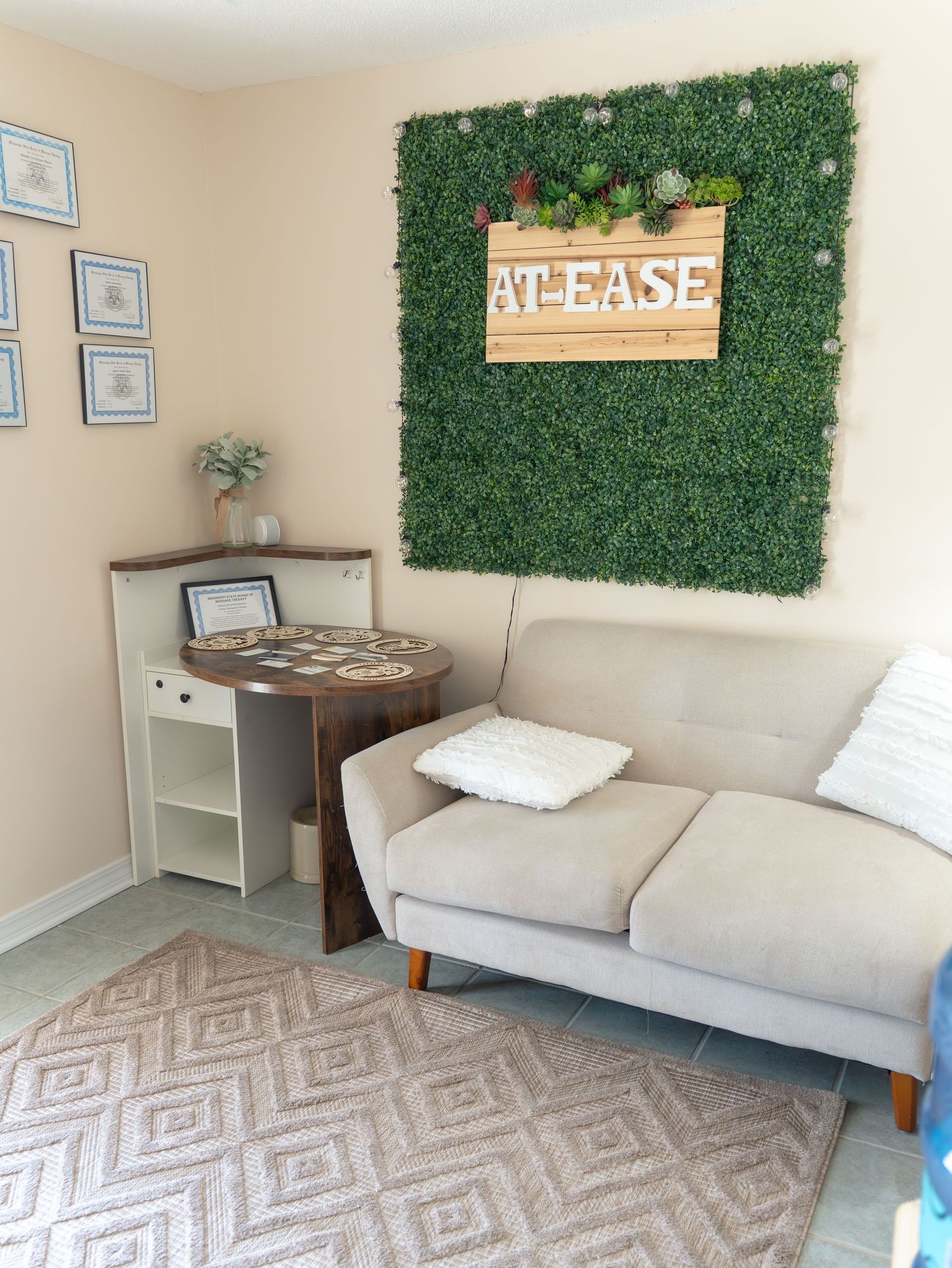 Modern living room featuring artificial grass wall decor and geometric rug pattern.