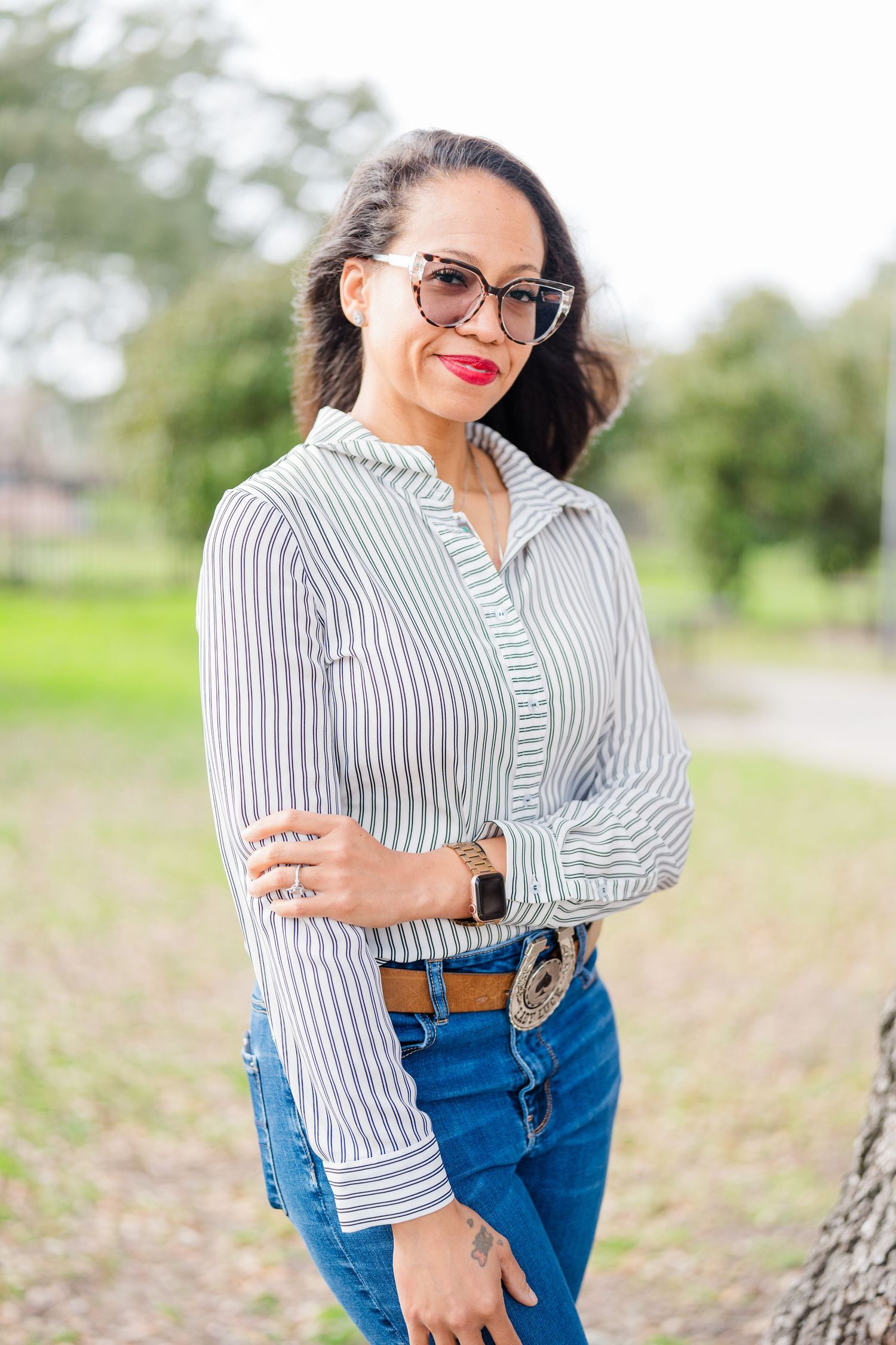 Outdoor fashion photos in striped shirt and jeans in natural setting.