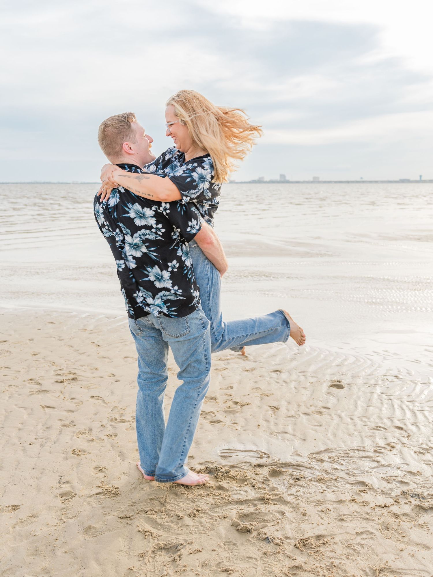 A playful beach engagement photoshoot featuring casual outfits and natural lighting.