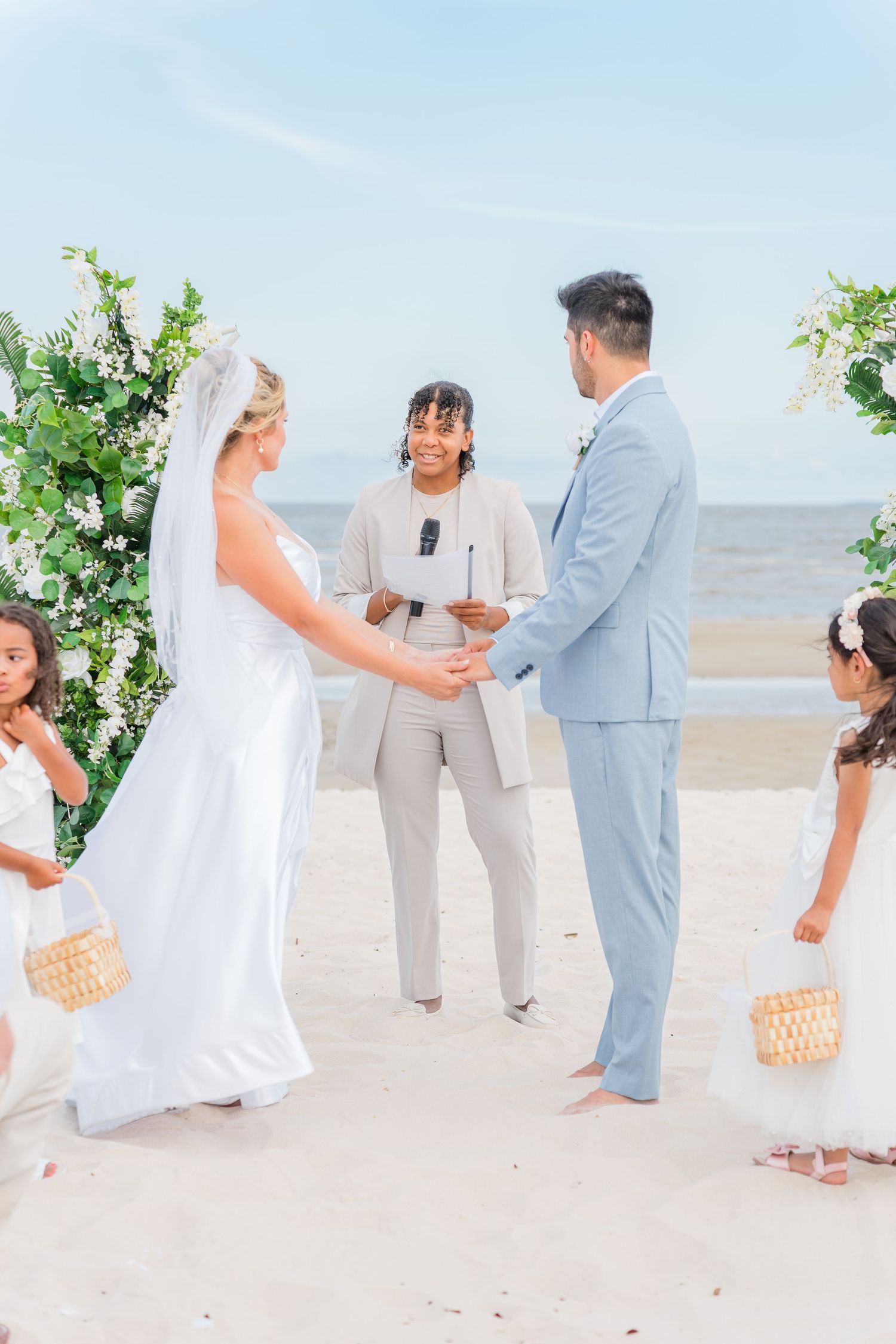Beach wedding ceremony sequence showing couple exchanging vows on white sand.