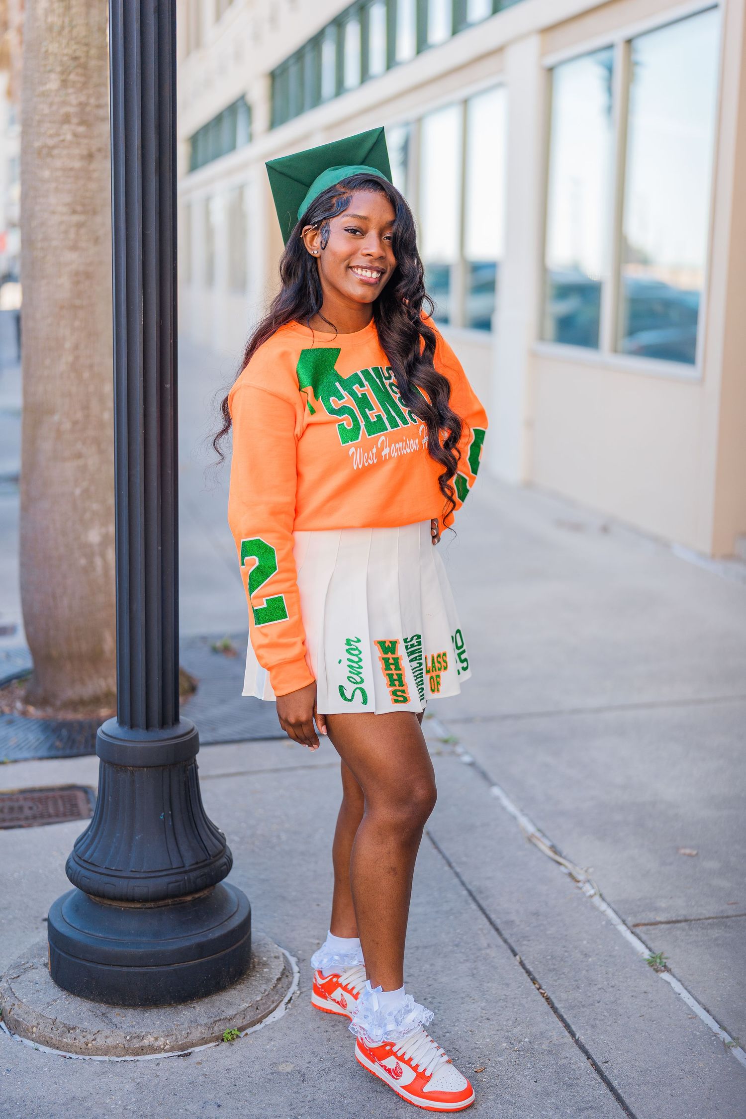 Orange university sweatshirt and sneakers shown on outdoor campus sidewalk.