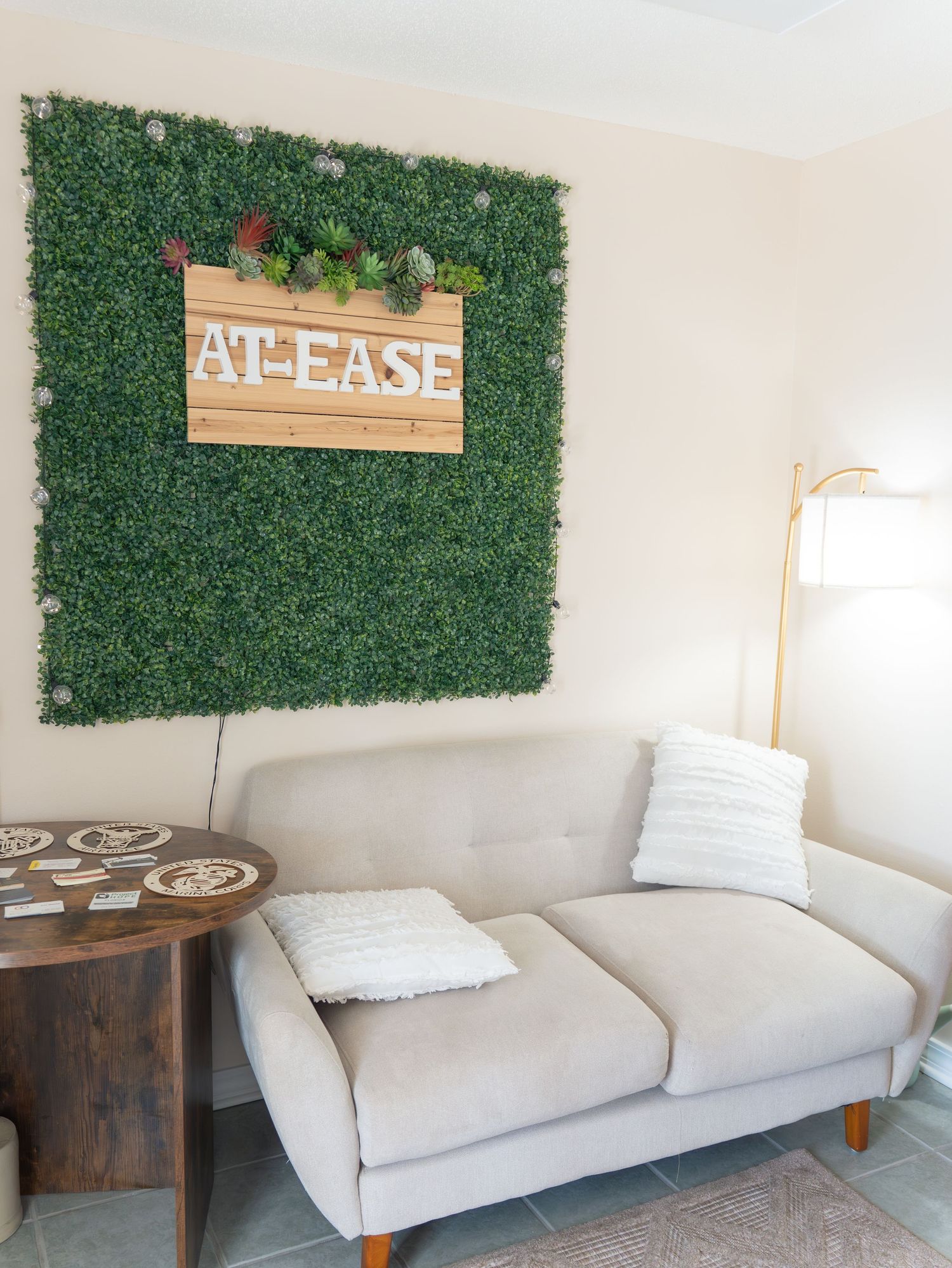 Modern living room with white sofa and decorative green wall panels.