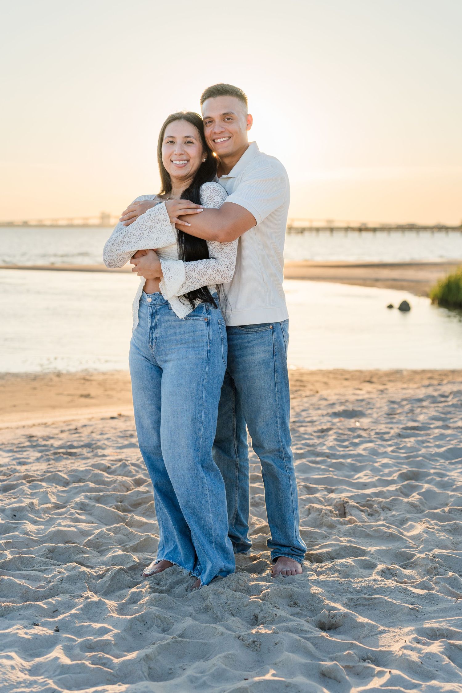 Beach photo session with couple in coordinated outfits during sunset.