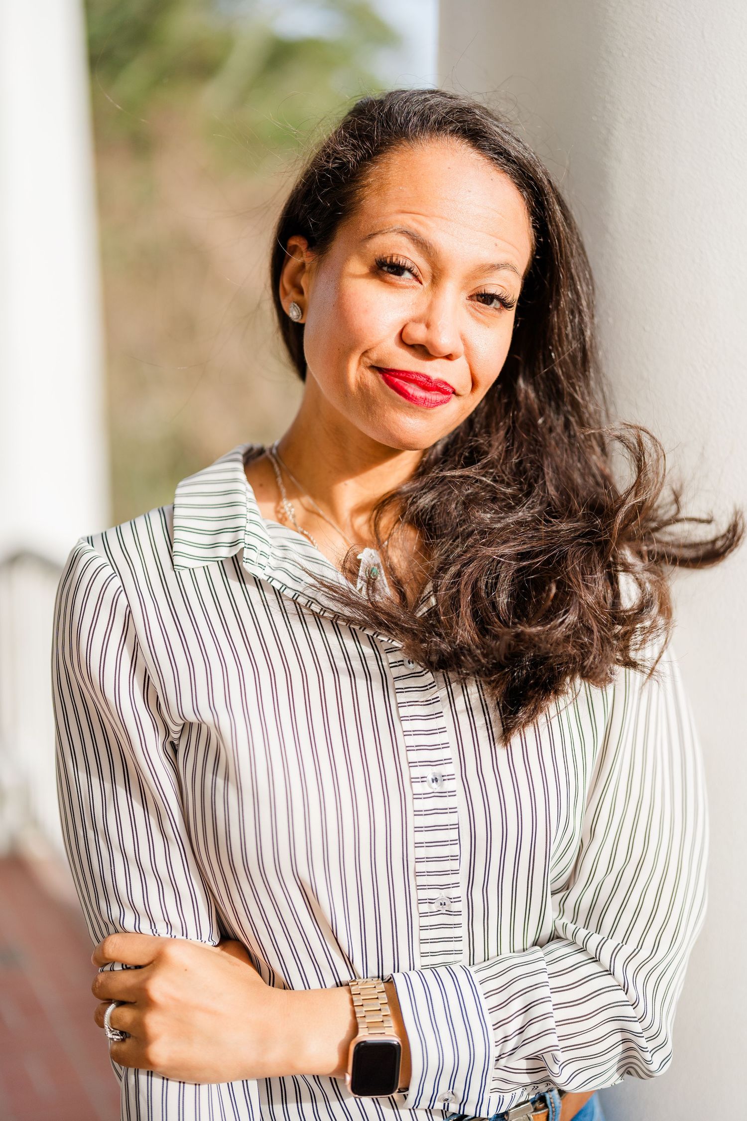 Fashion portraits in striped button-down shirt with natural hair movement.