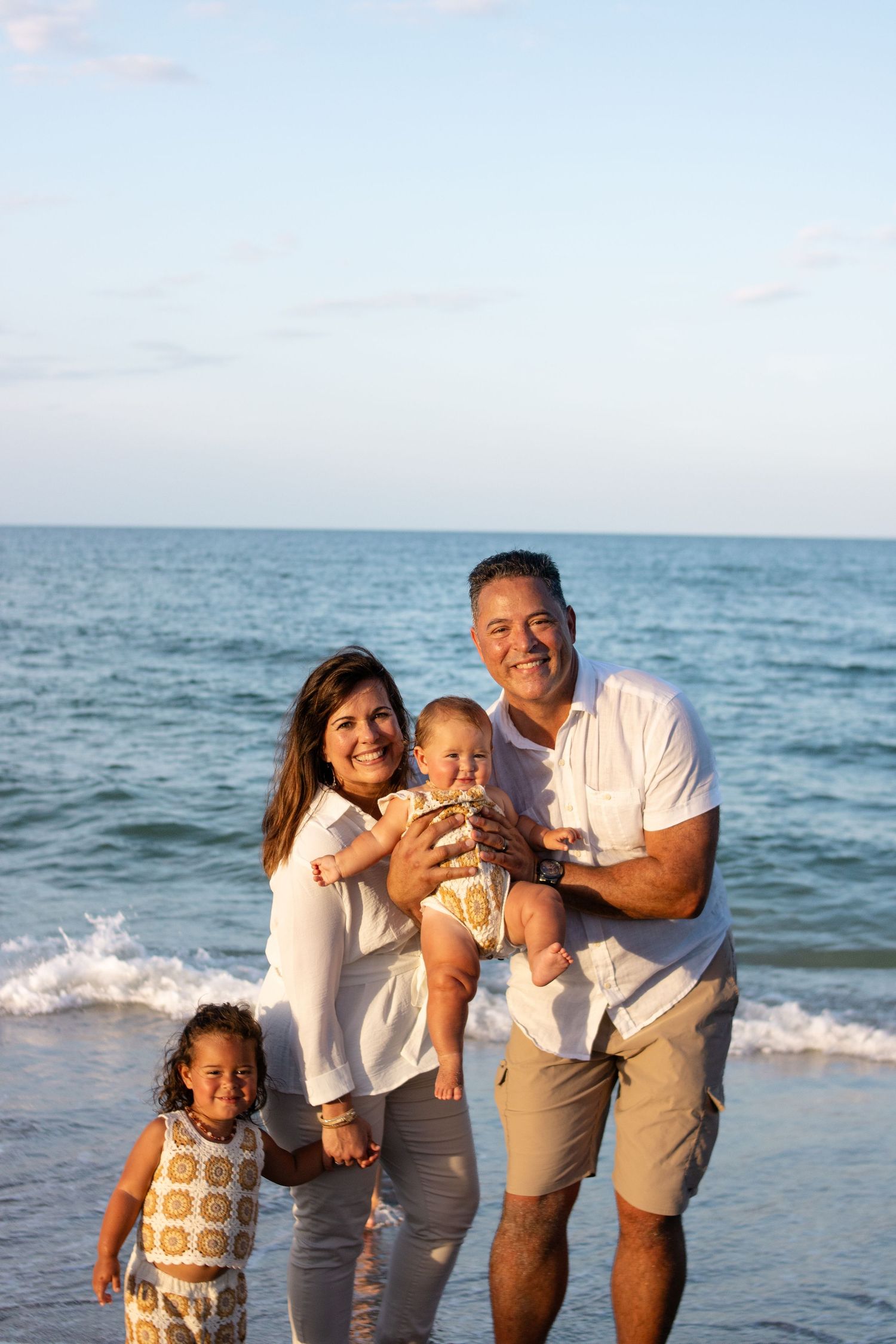 family smiling at camera on the beach