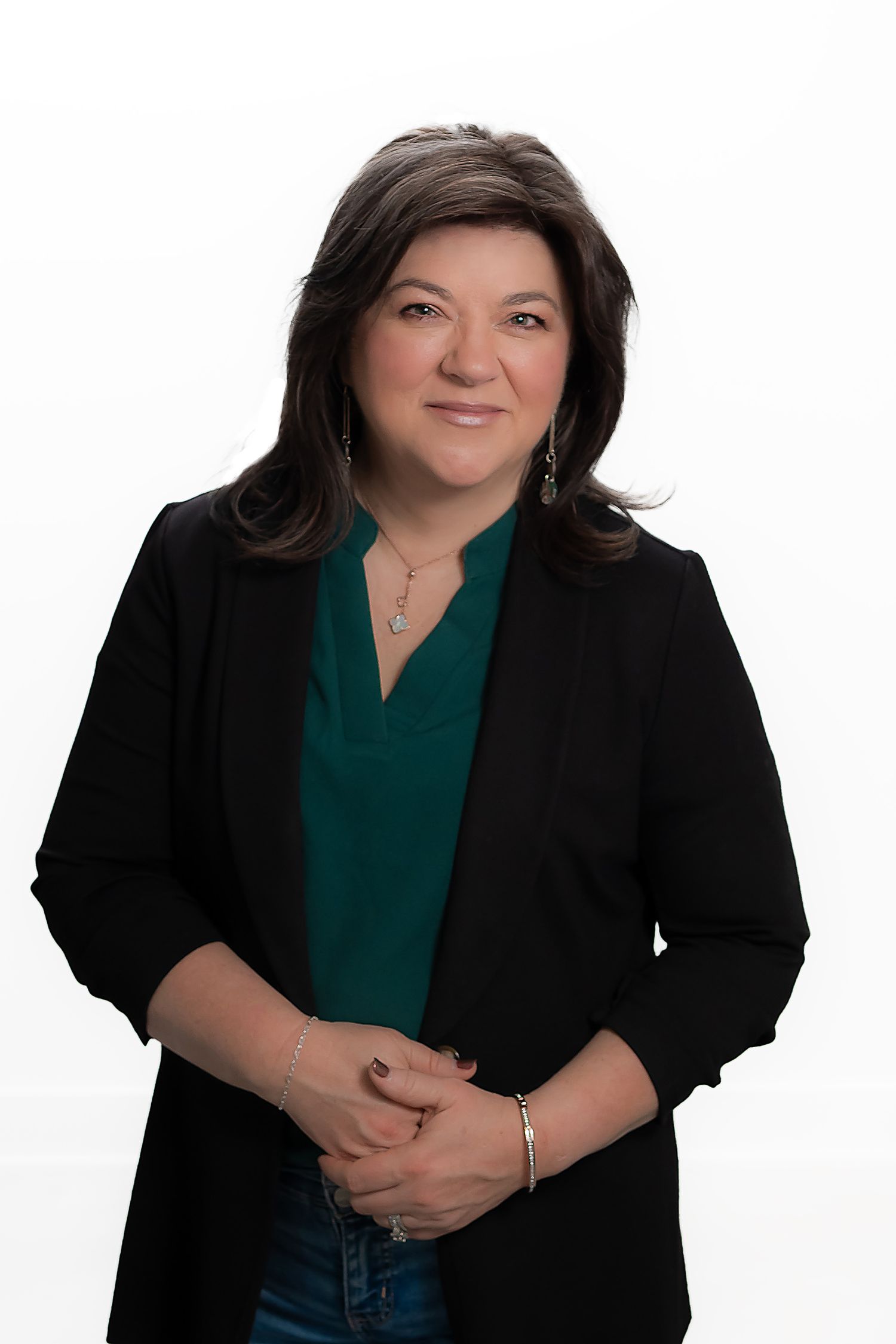 Business portrait of a woman in a black blazer and green top on a white background