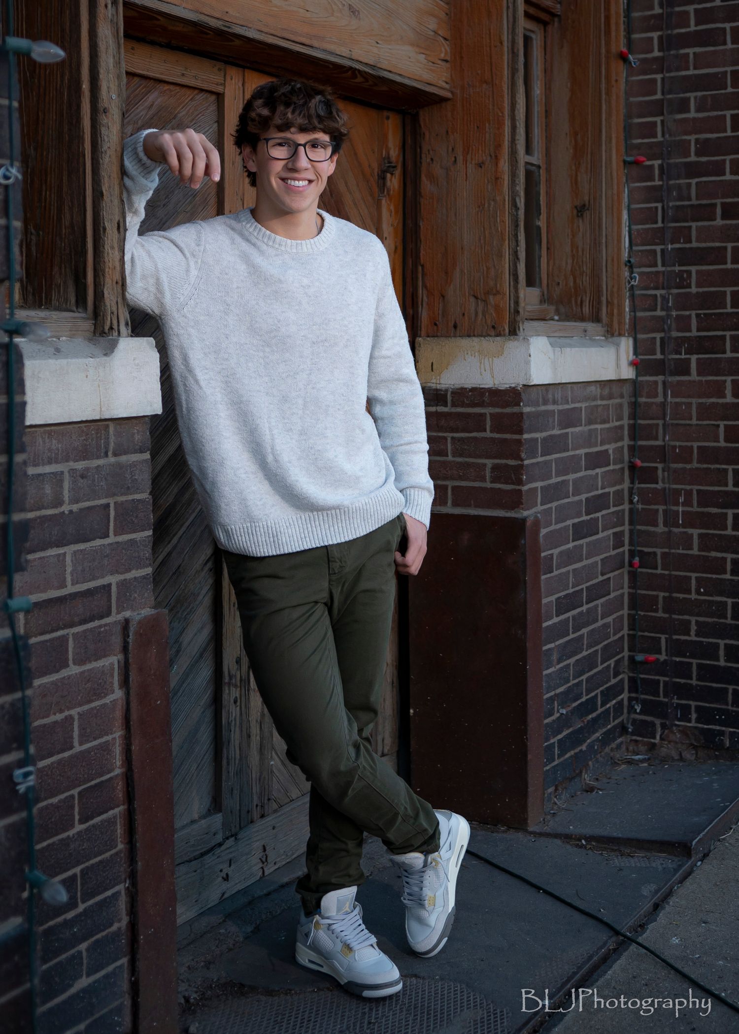 Senior portraits/West Bottoms/ boy resting against brick wall with hand in pocket
