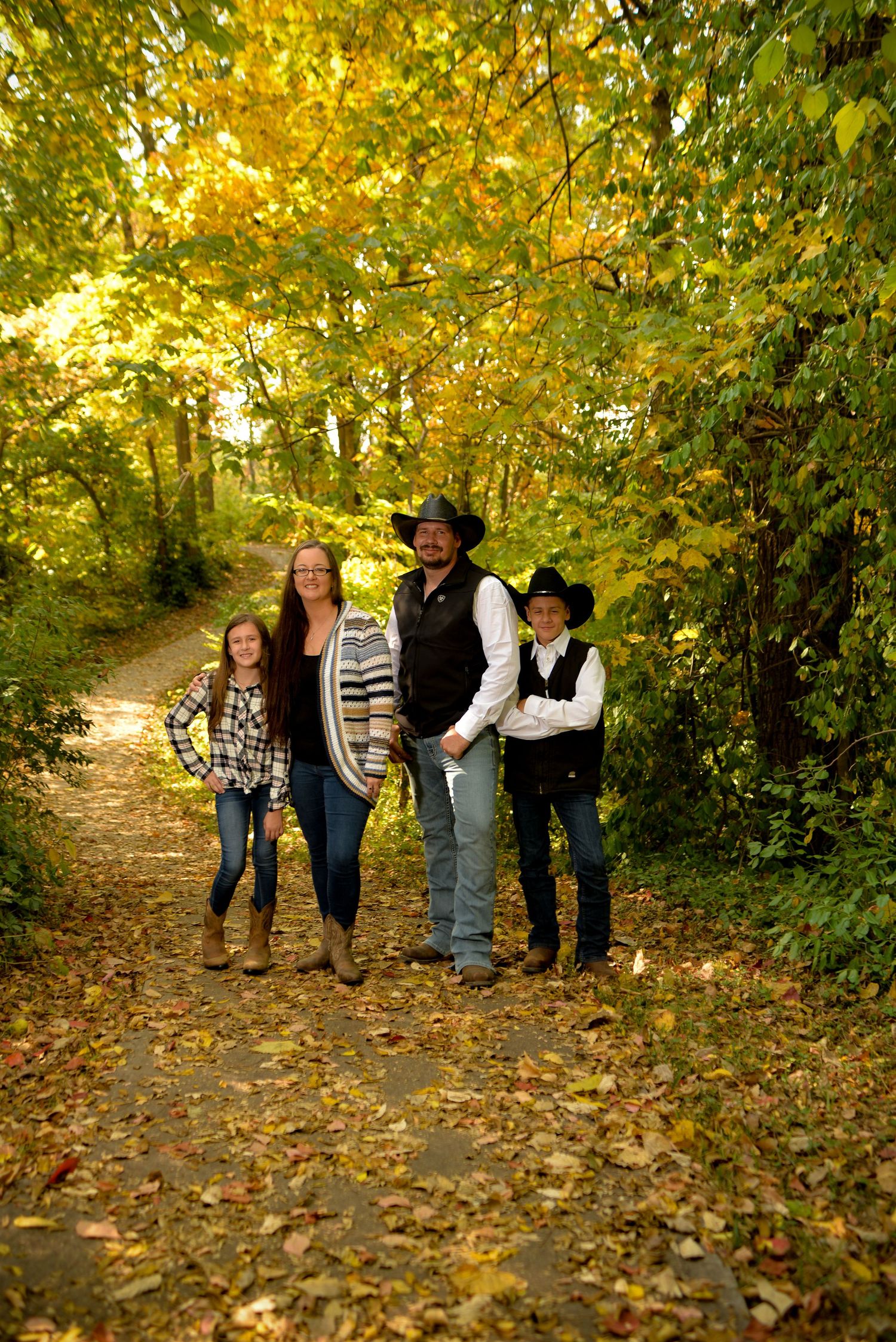 Family Portrait of mom, dad, and two children in a wooded area at Penguin Park in Kansas City