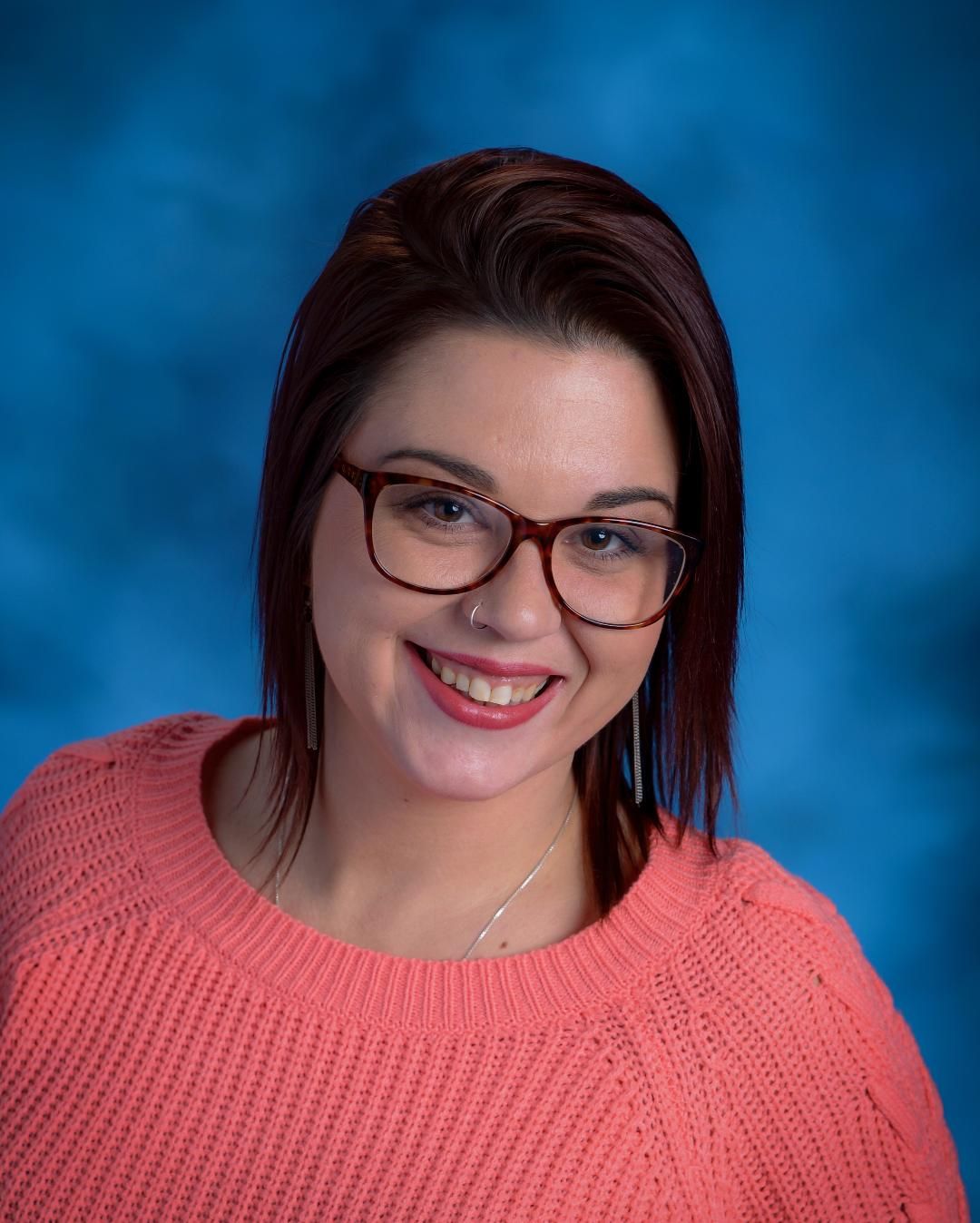 Portrait of woman with coral sweater on a blue background