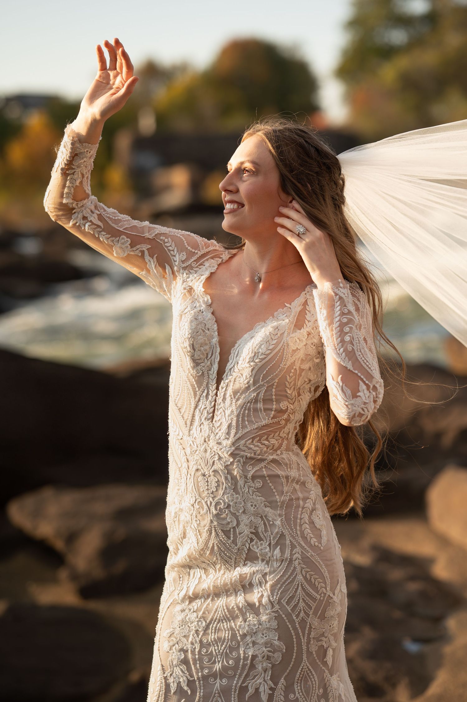 Artistic bridal portraits showing movement of lace dress and veil against natural outdoor setting.