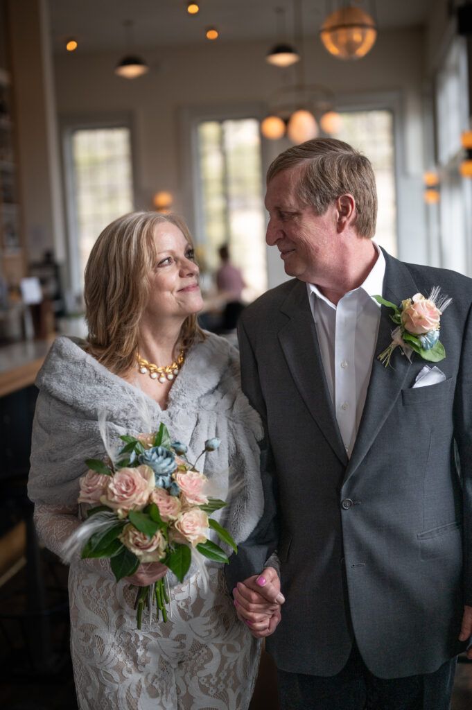 Senior Couple, bride and groom, walking hand and  hand in the bar at the Surf Hotel. The couple is happy, smiling, and looking at each other