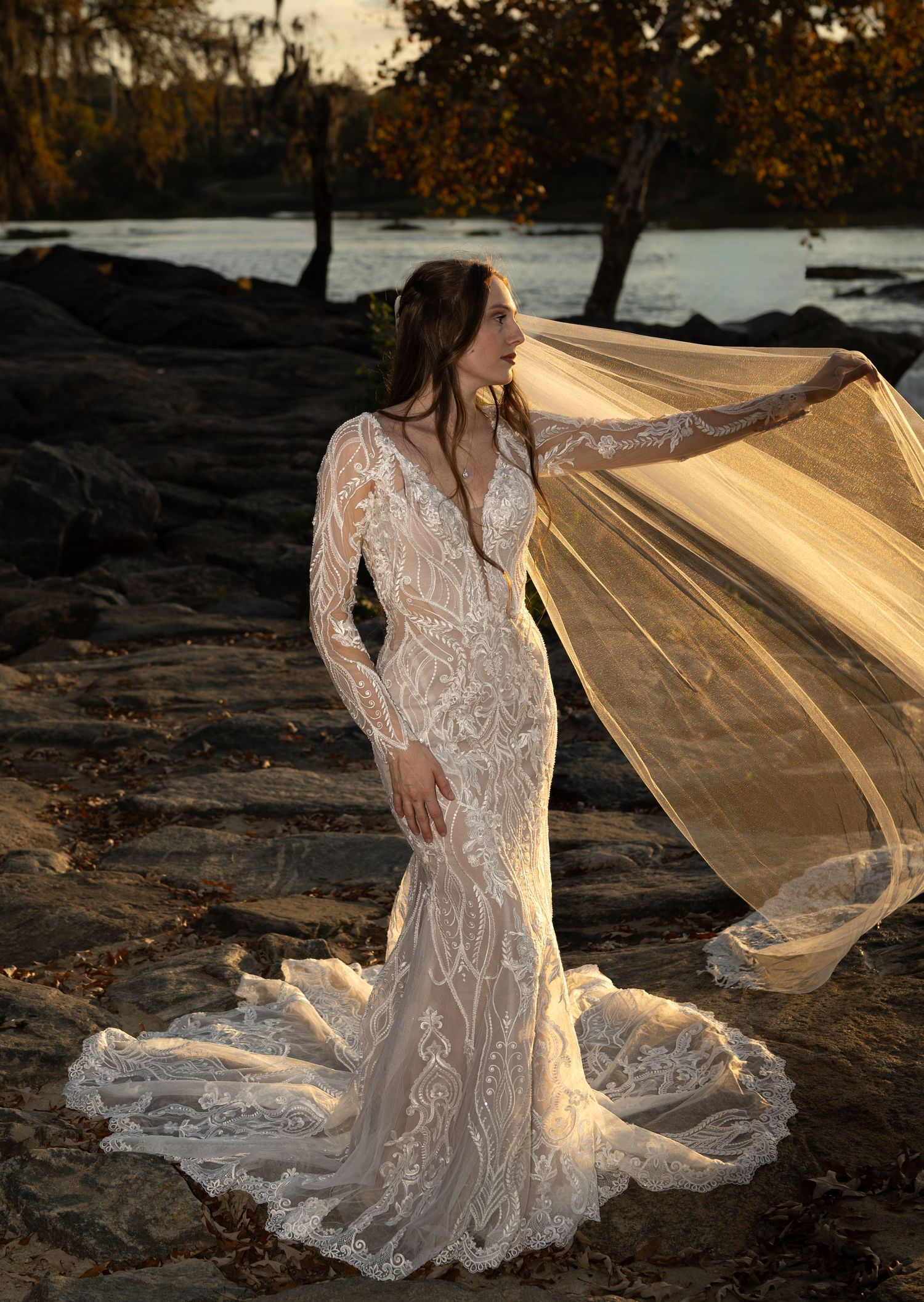 Sunset bridal photos with golden light illuminating lace gown and flowing veil.