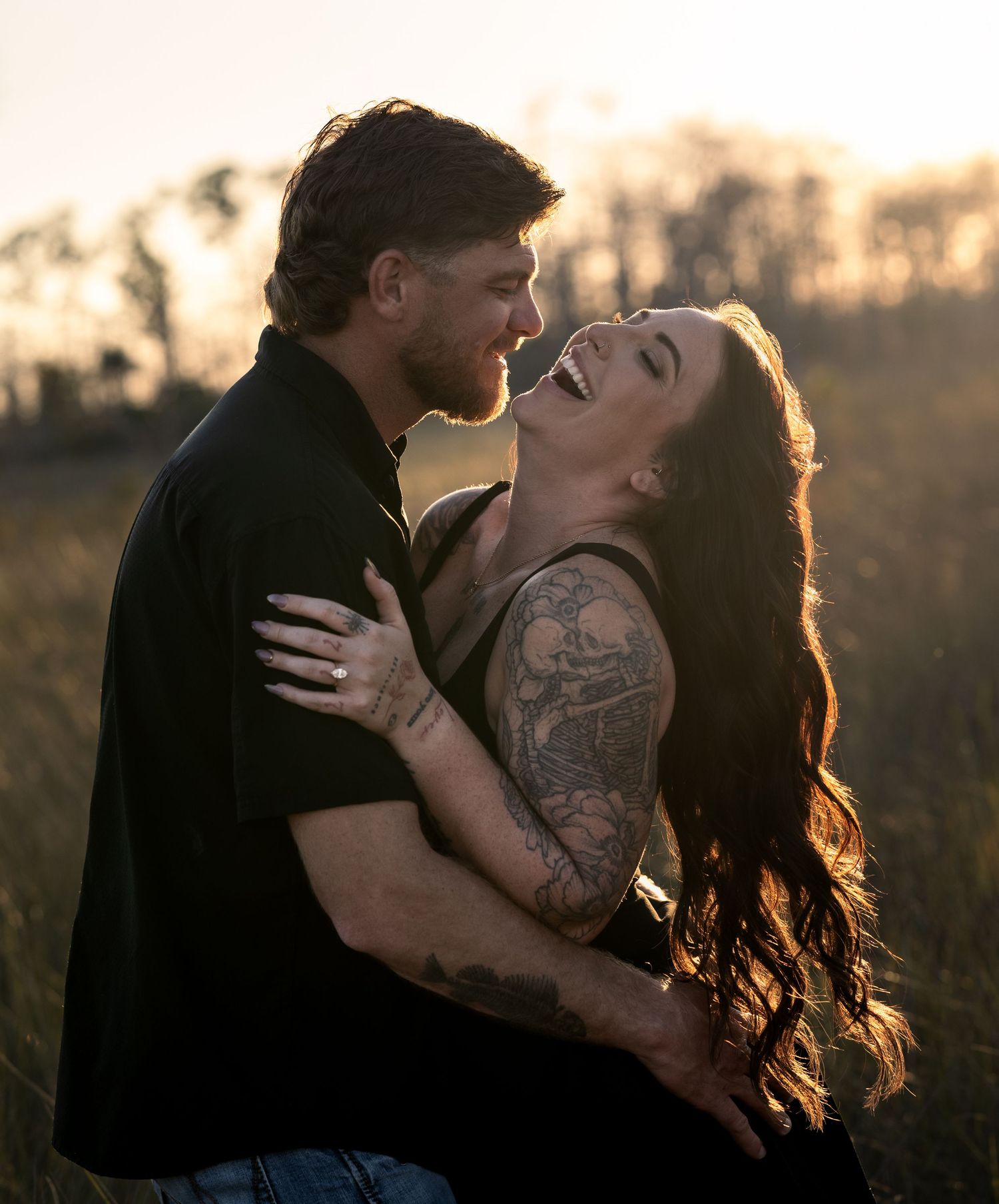 Silhouetted figures embrace tenderly against a warm sunset backdrop in a natural outdoor setting.