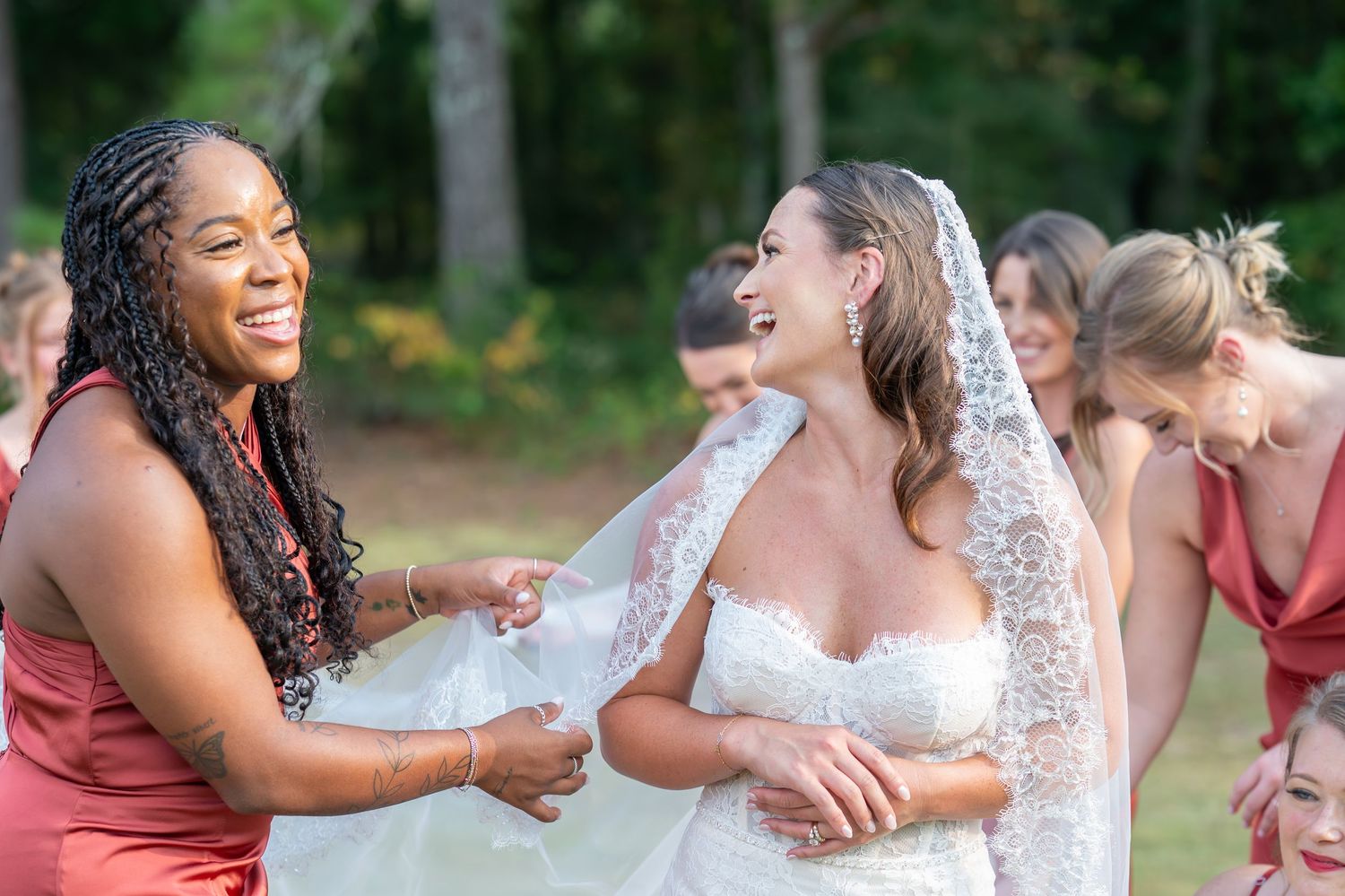 Wedding party enjoying candid moments and laughter together outdoors.