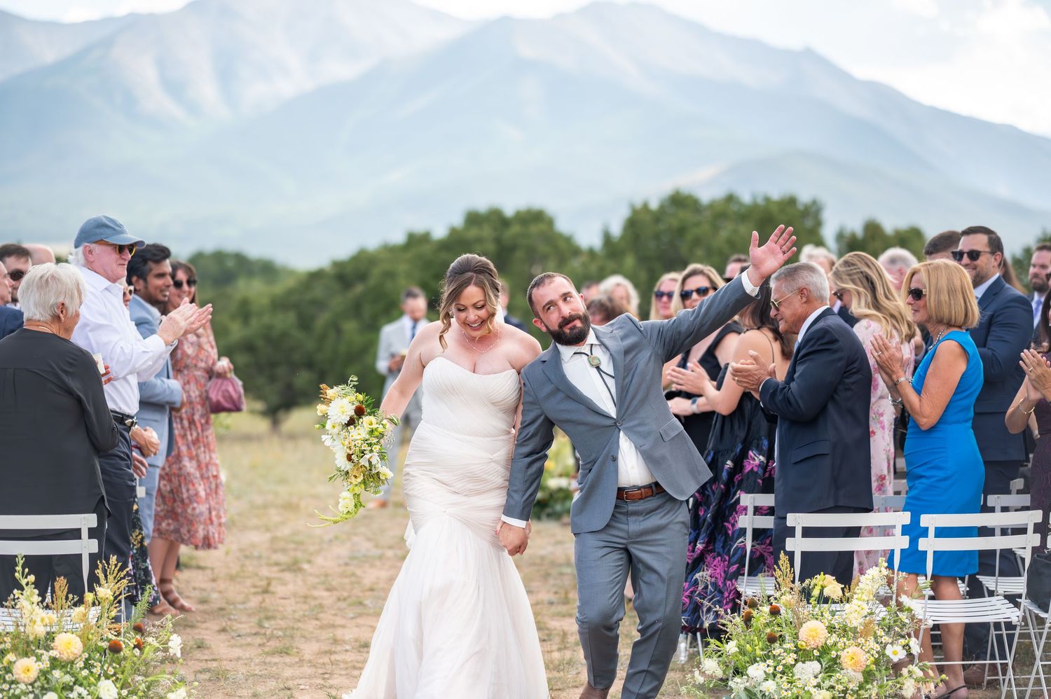 Wedding ceremony taking place outdoors with guests watching the couple exchange vows at the Meadows wedding venue in Buena Vista, Colorado.