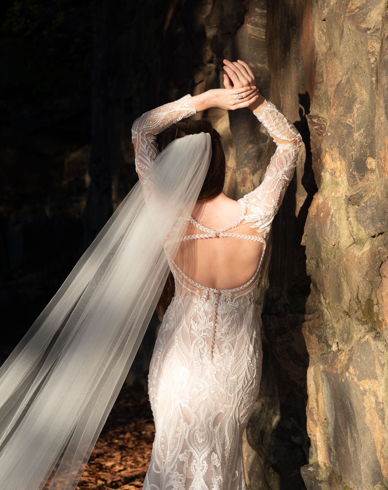 Artistic bridal portraits showing intricate back details of a lace wedding gown against a textured backdrop.