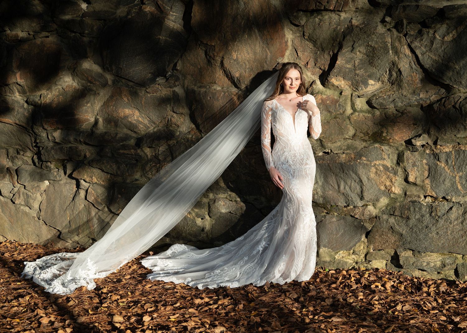 A dramatic bridal photo series featuring a lace gown against rocky cliffs and autumn leaves.
