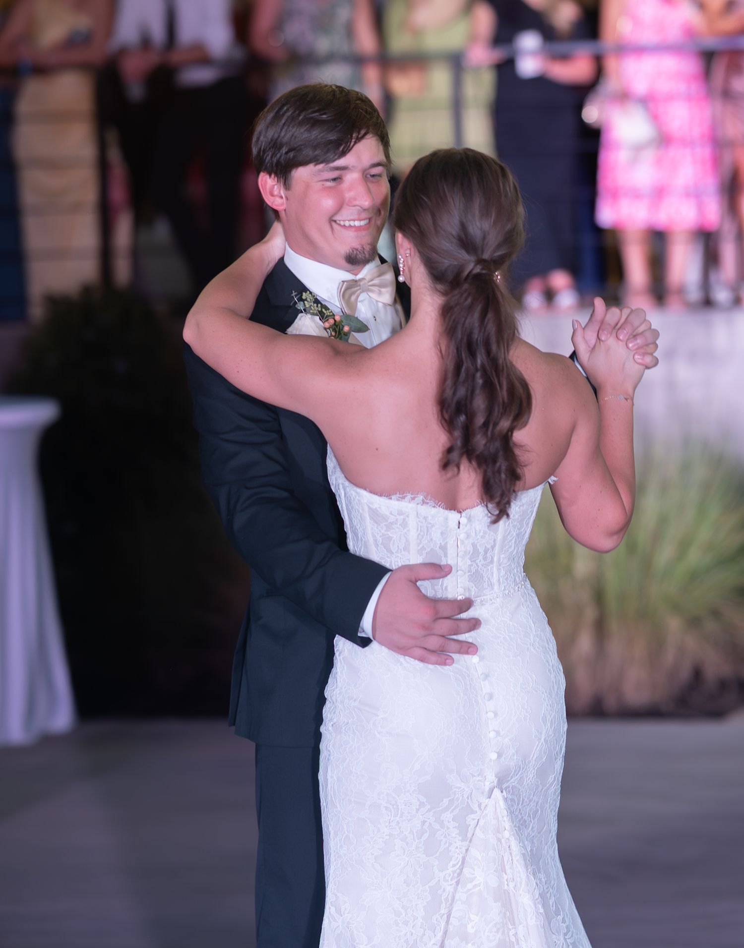 Couple dancing together at their wedding reception in formal attire.