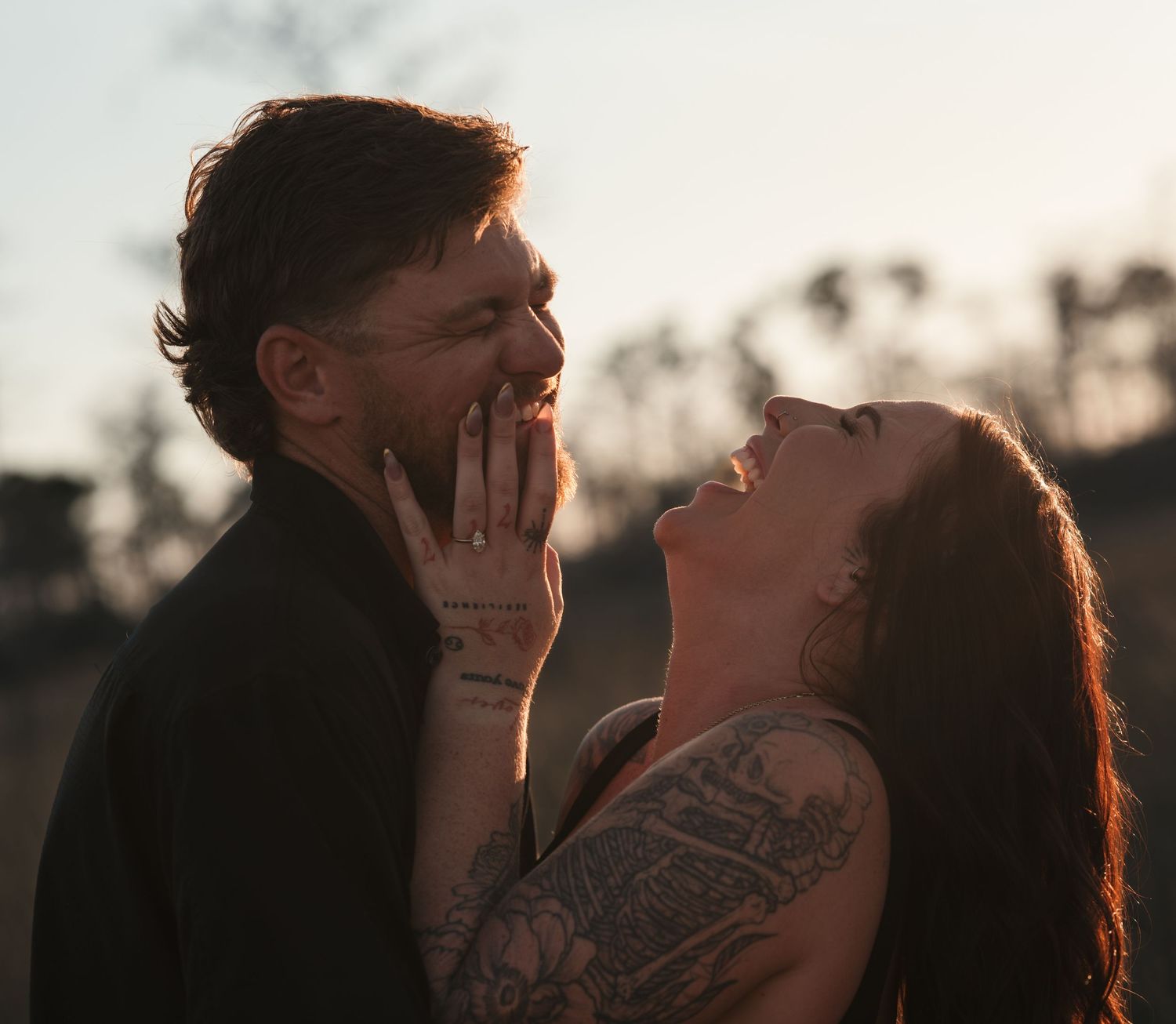 Intimate close-up portrait of a couple sharing tender moments during golden hour in a natural outdoor setting.
