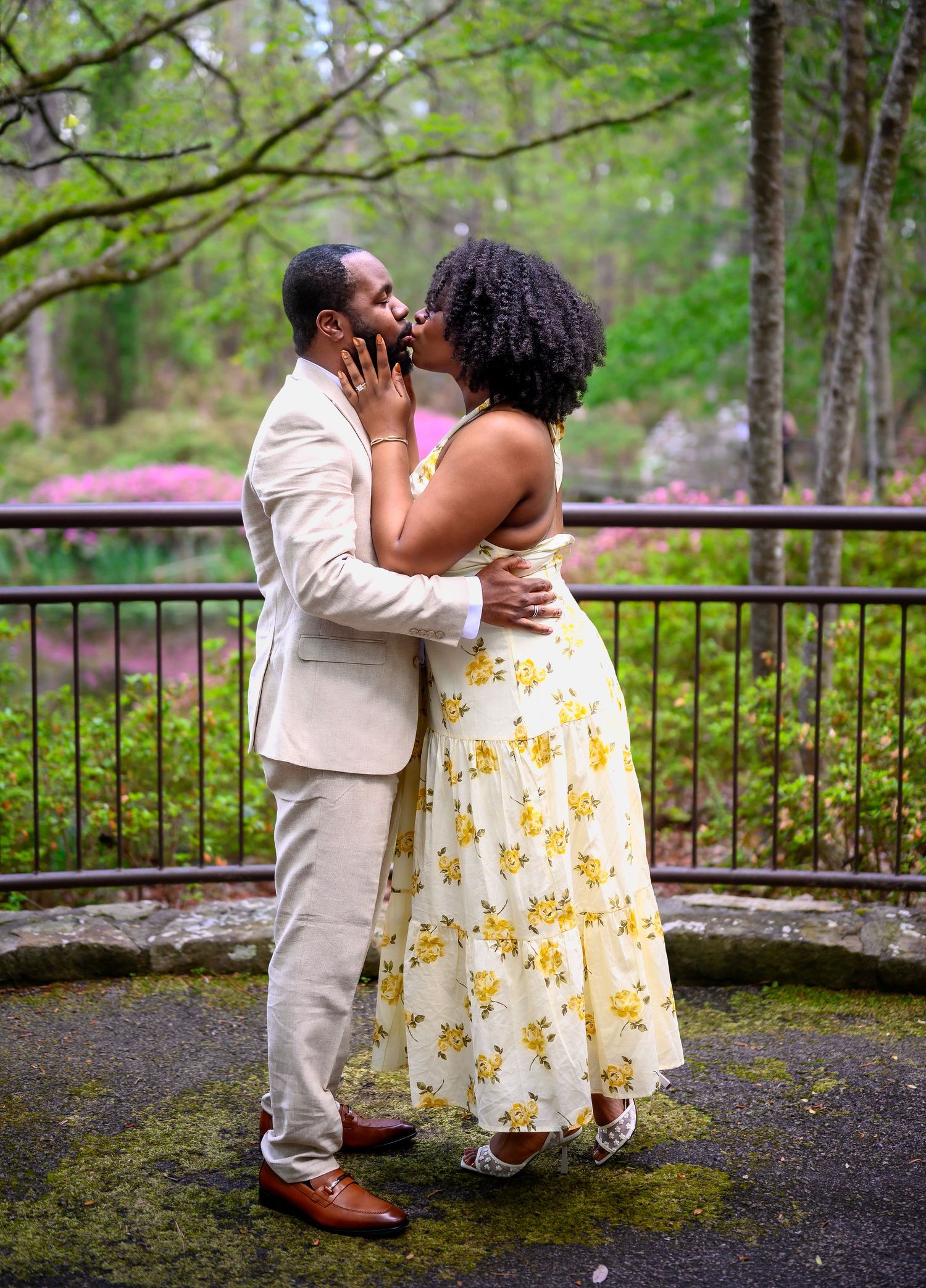 Couple sharing romantic kiss at outdoor garden wedding ceremony.