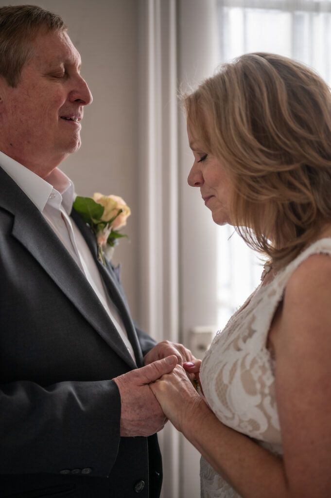 Senior Couple, Bride & Groom, praying at their elopement at the Surf Hotel in Colorado. They are holding hands and praying as Mr. & Mrs.