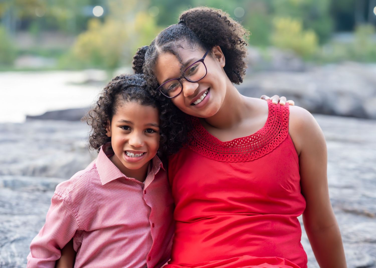 Joyful family moments captured during outdoor maternity photoshoot by the river.