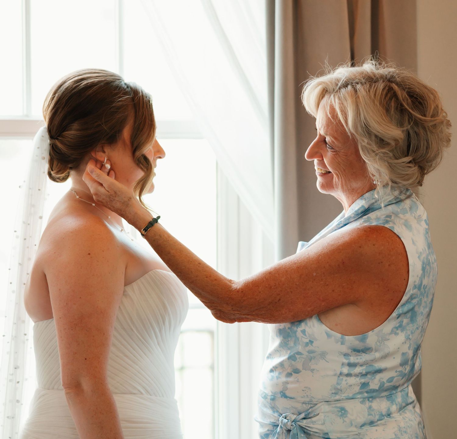 Getting ready sequence shows final touches being made to wedding attire in sunlit room.