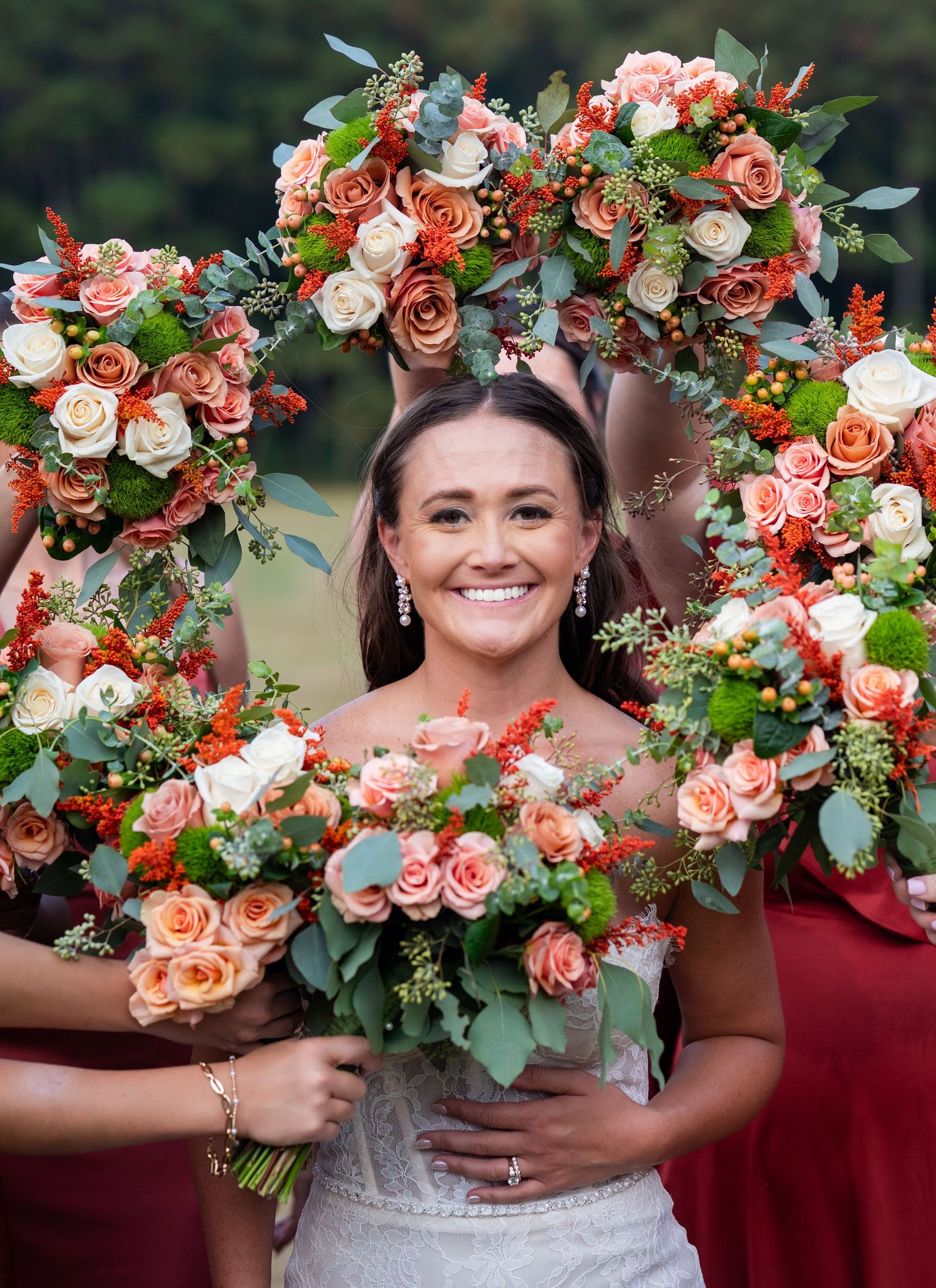 Beautiful coral and white rose bouquets with greenery arranged for wedding photos outdoors.