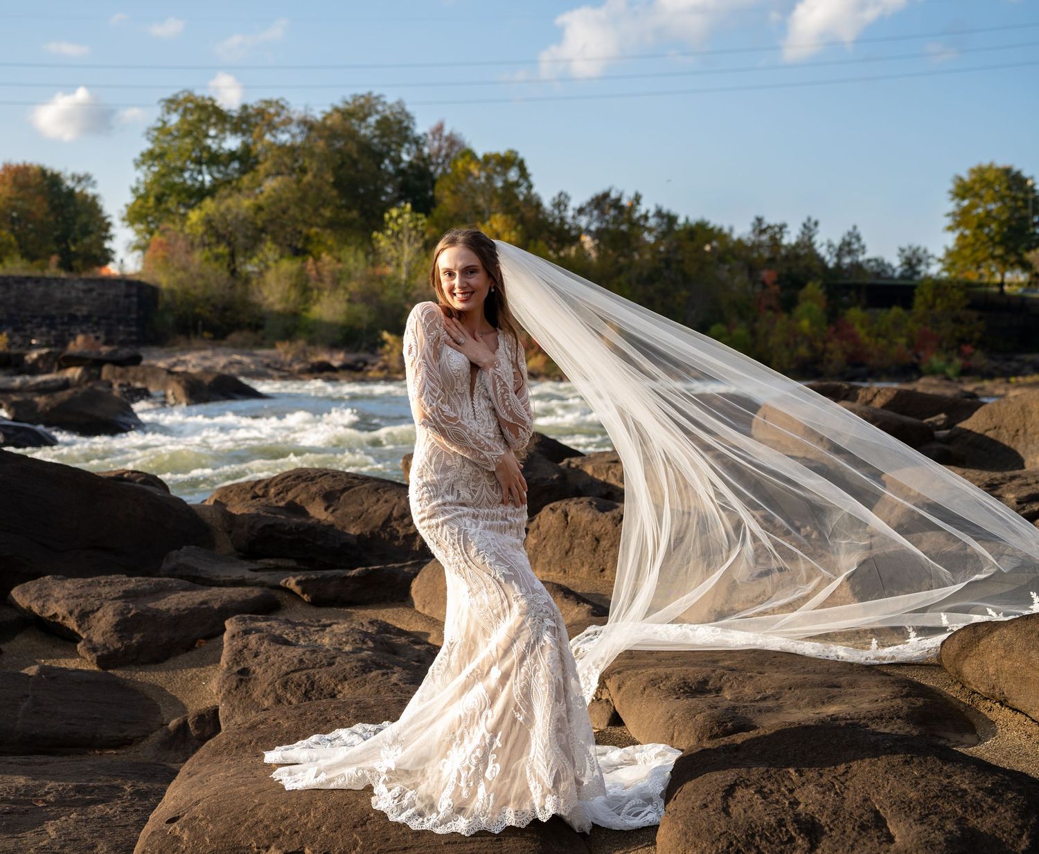 A wedding dress photoshoot on rocky terrain with dramatic veil movement.