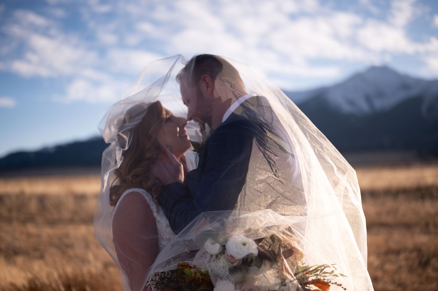 A romantic moment at sunset with mountains in the distance.