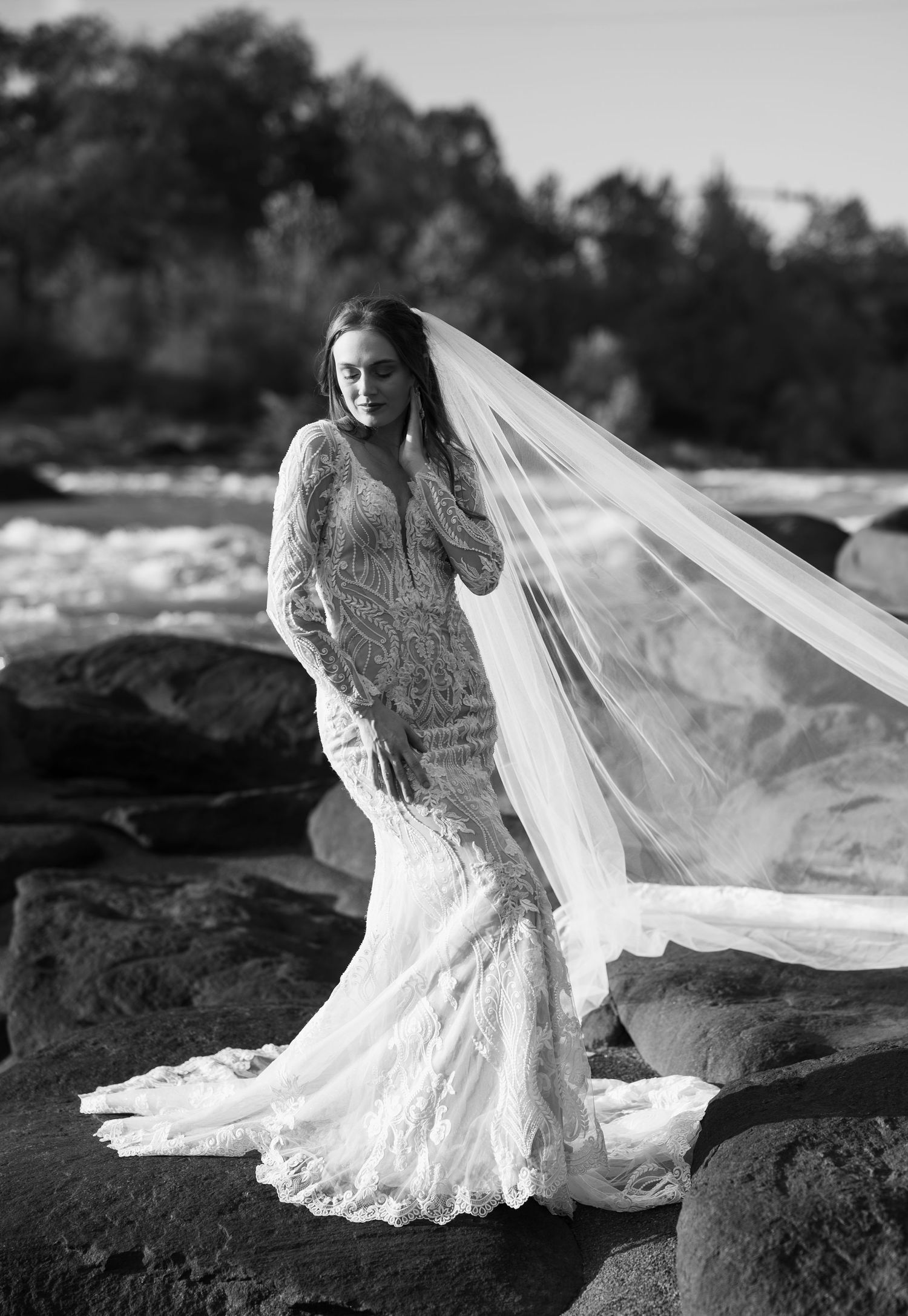 Monochrome bridal portraits on rocky terrain with dramatic veil movement.