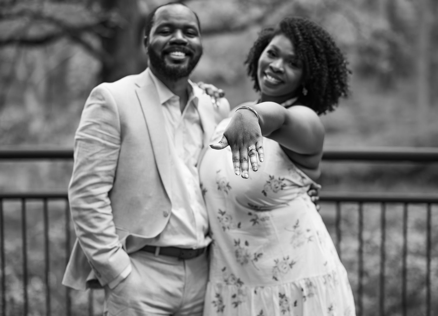 Black and white photo of a happy couple embracing and smiling together outdoors.