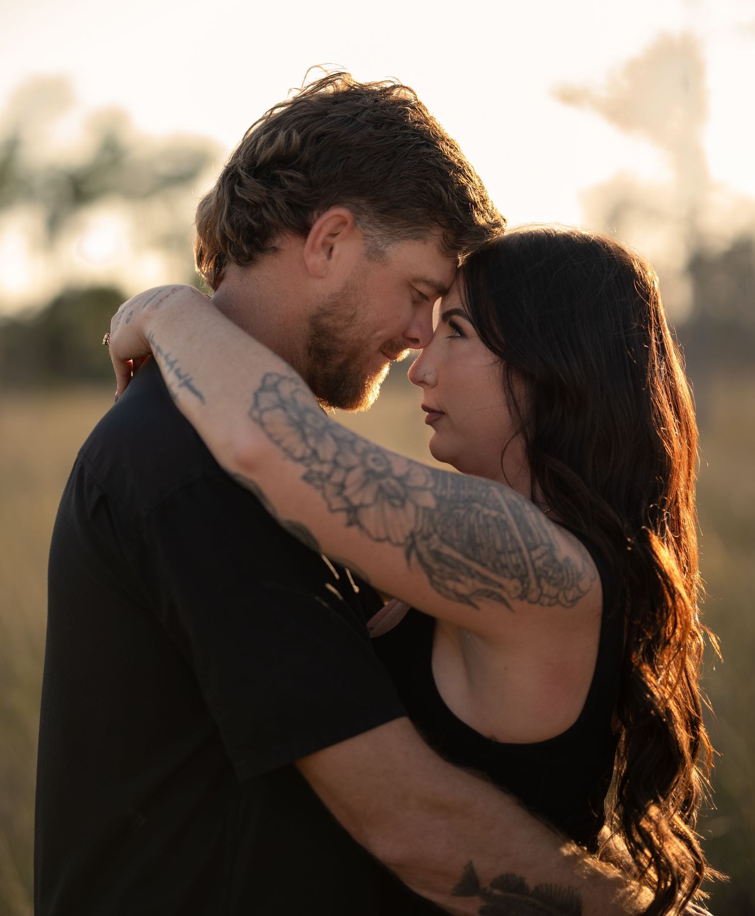 Intimate portrait of a couple sharing tender moments in warm evening light.