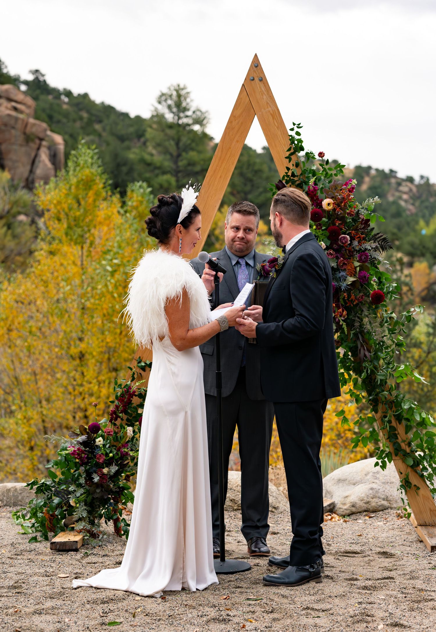 Wedding ceremony under triangular wooden arch decorated with autumn foliage at the Surf Hotel in Buena Vista, Colorado