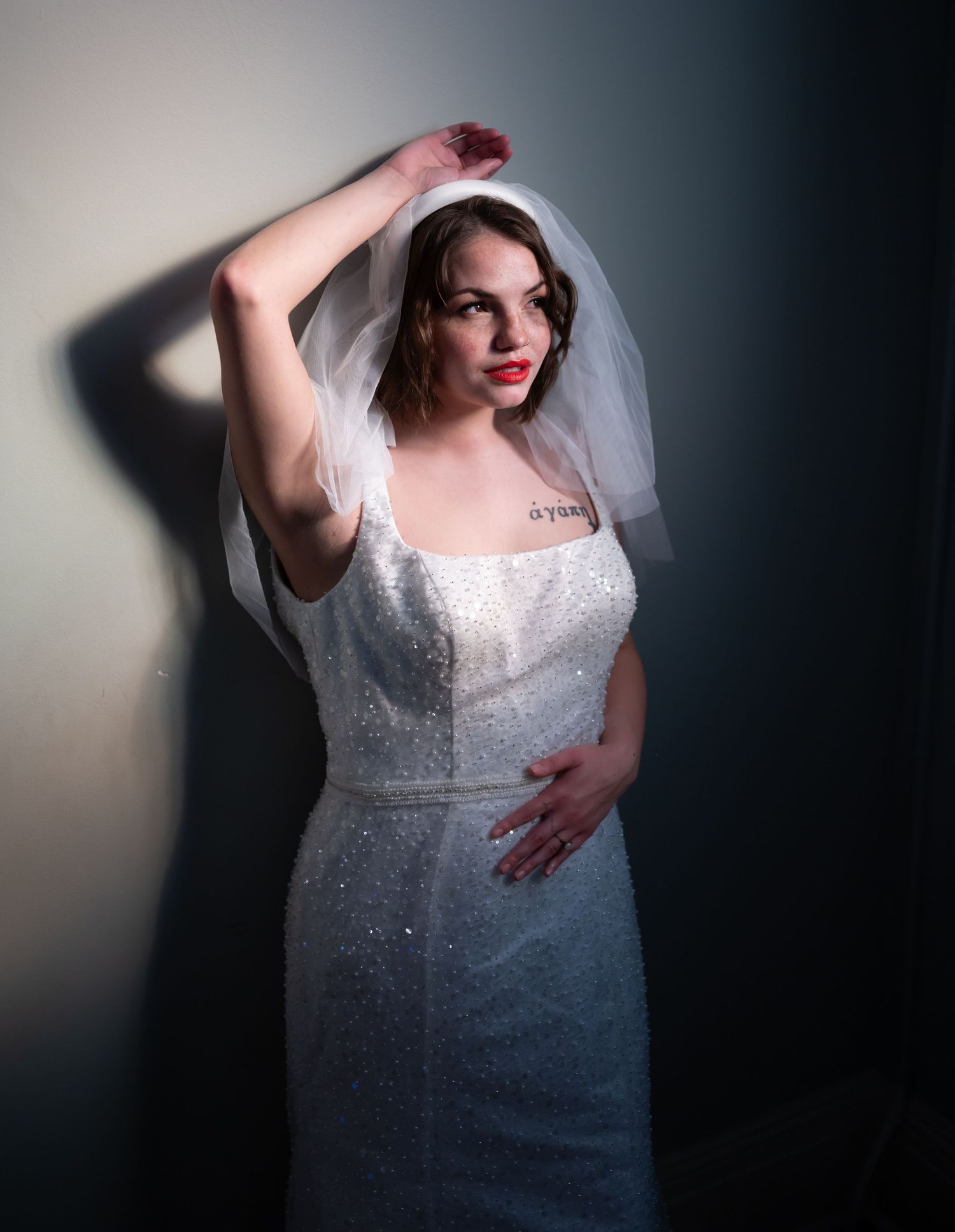 A bridal portrait series in dramatic lighting showcasing a lace wedding gown with a gradient blue-dyed effect.