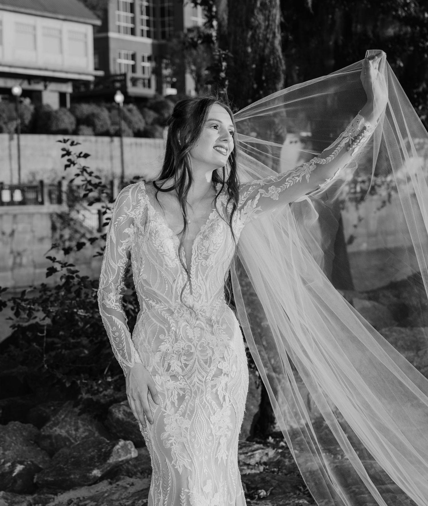 Classic black and white bridal portrait with flowing veil and lace gown details.