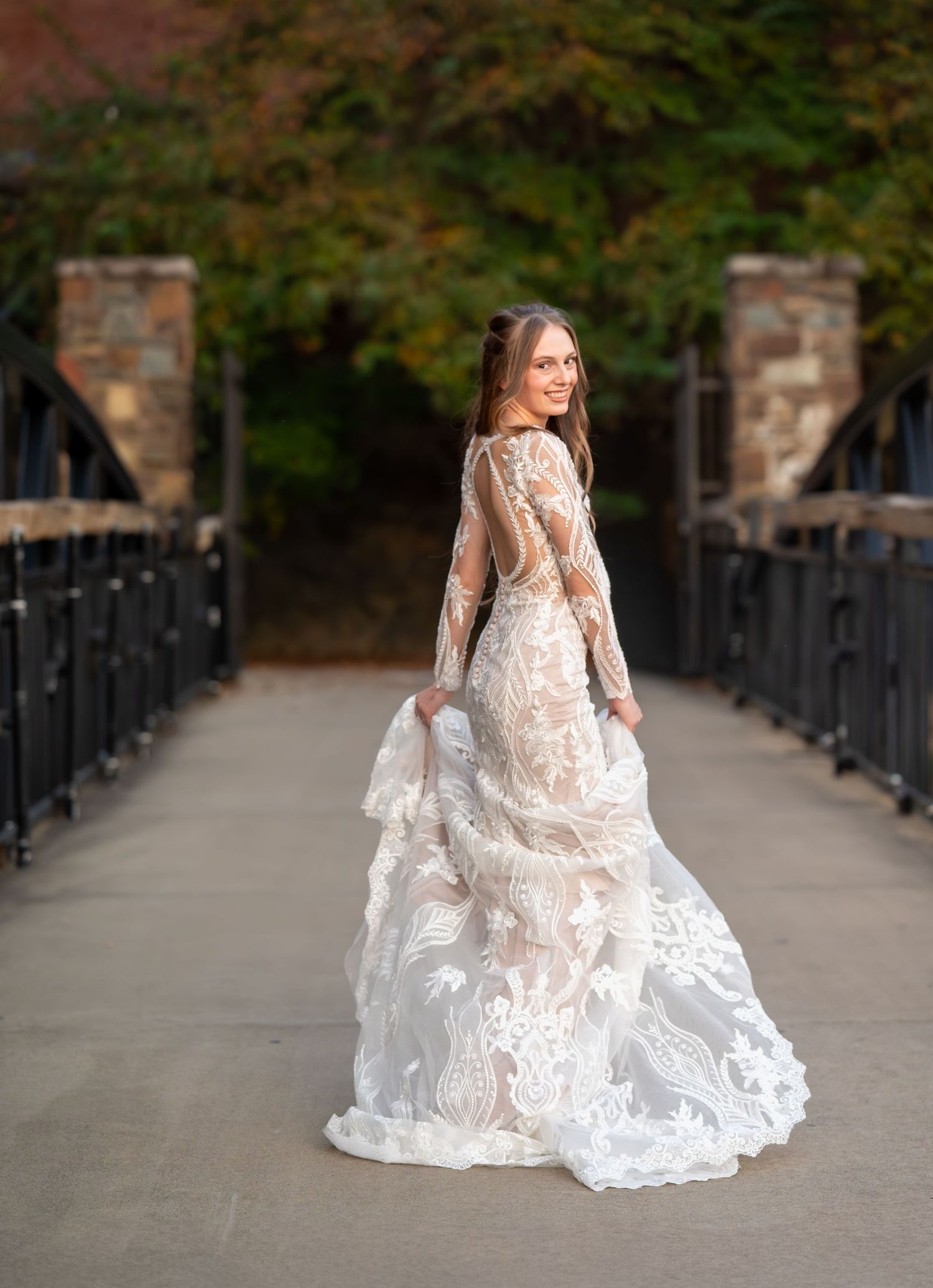Elegant bridal portraits on stone pathway with full lace gown and dramatic train.