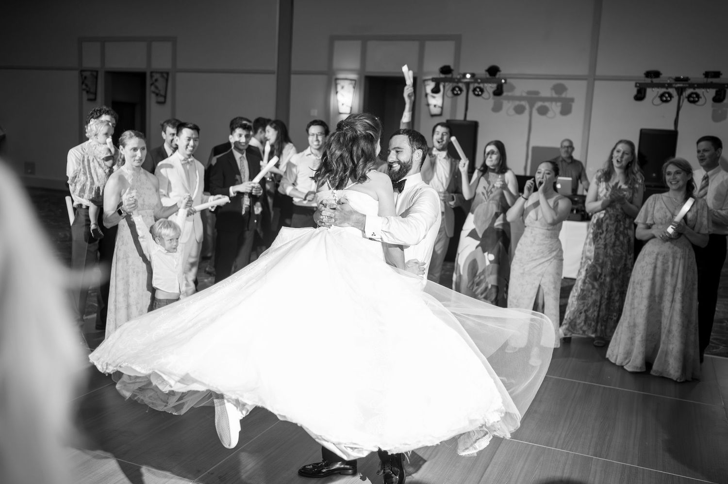 Black and white photos show wedding guests dancing and celebrating at a reception venue.