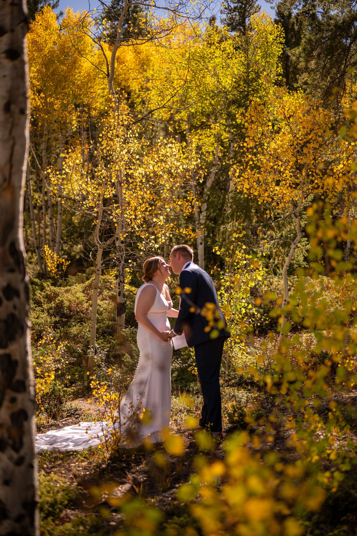 Wedding ceremony among golden aspen trees during fall in mountain forest.