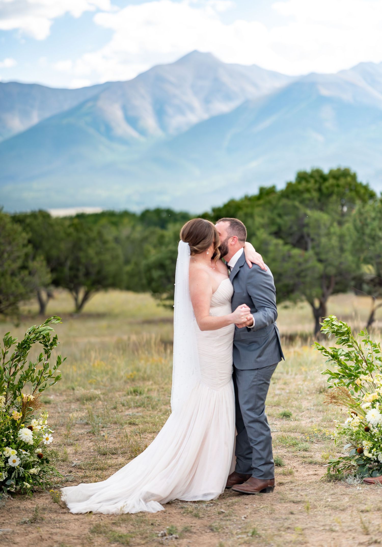 Intimate wedding ceremony in mountain field with natural decor and scenic backdrop at the Meadows wedding venue in Buena Vista, Colorado.