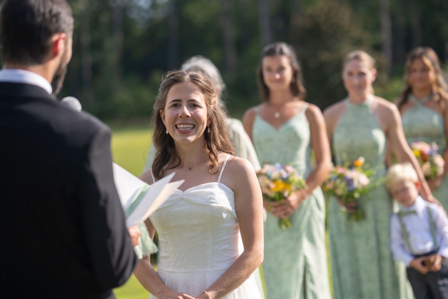 Wedding party in pastel attire gathered for outdoor ceremony celebrations.
