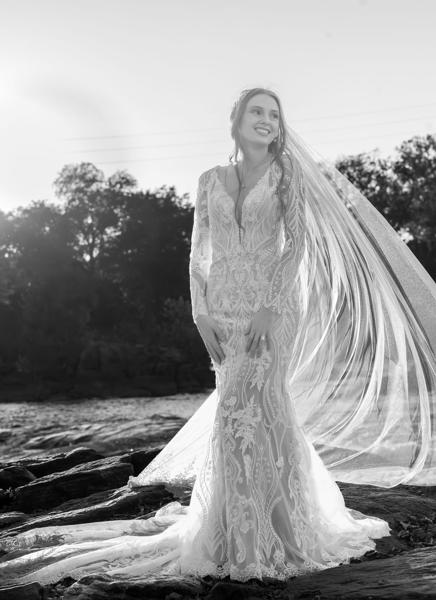 Black and white bridal portraits with cathedral veil flowing in sunlight.