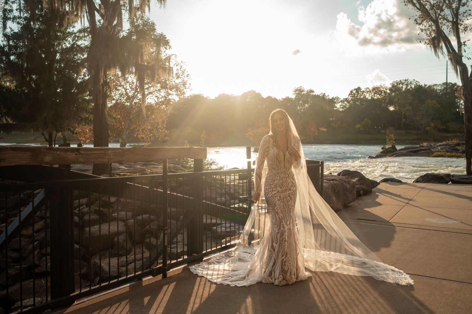 Sunset bridal photography with dramatic backlighting and flowing veil silhouette.