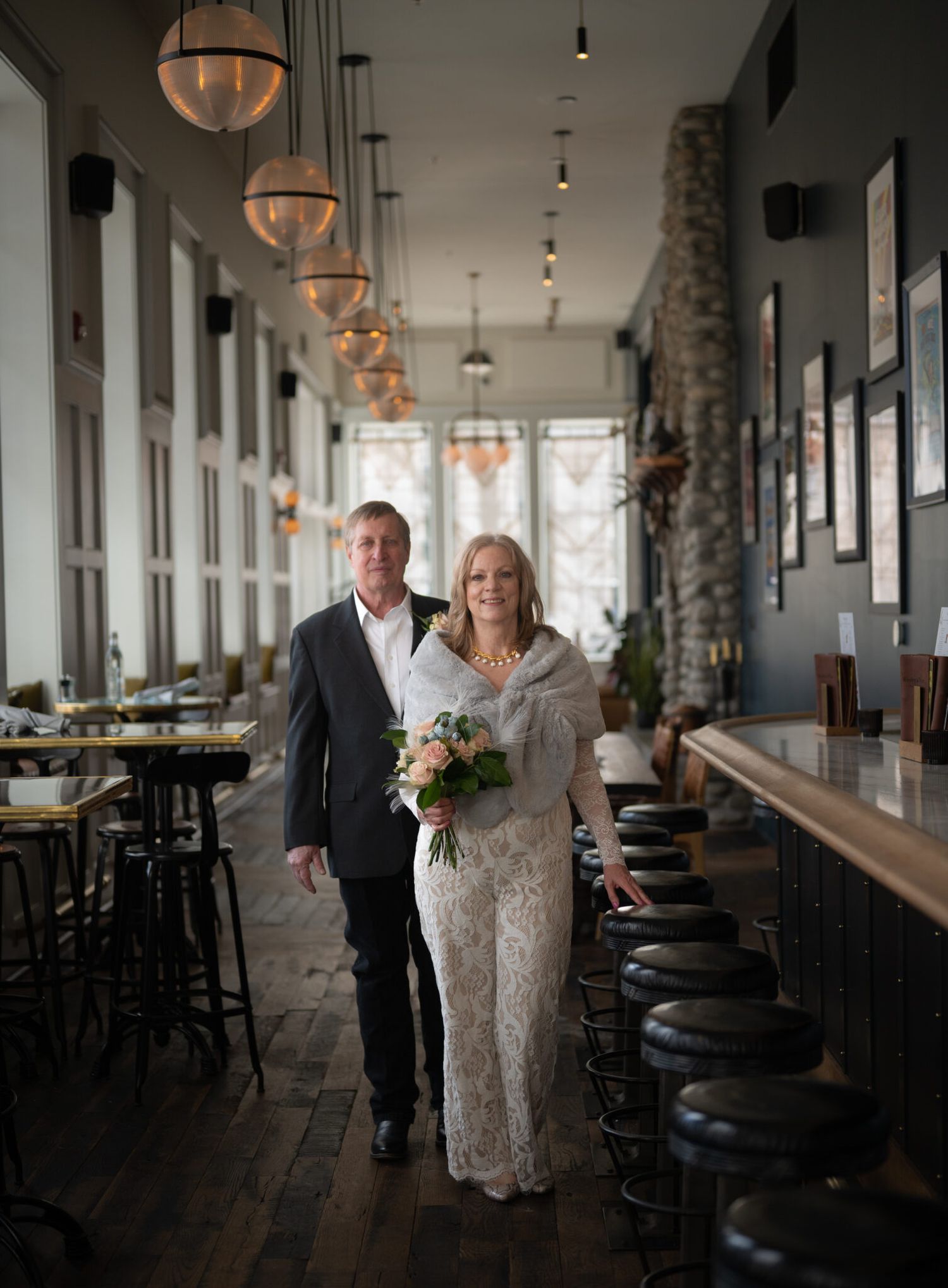 recently married husband and wife are walking through the bar at the Surf Hotel. The photo captures their excitement about their elopement