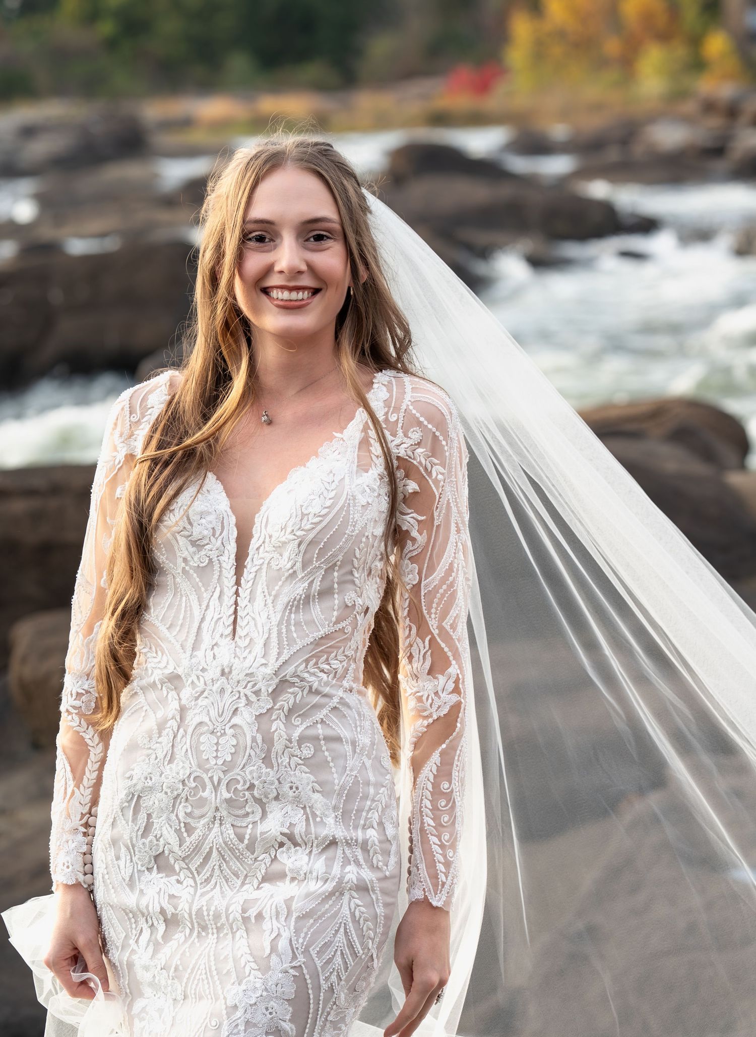 A bridal portrait series showing a lace wedding dress with long sleeves against a dramatic waterfall backdrop.