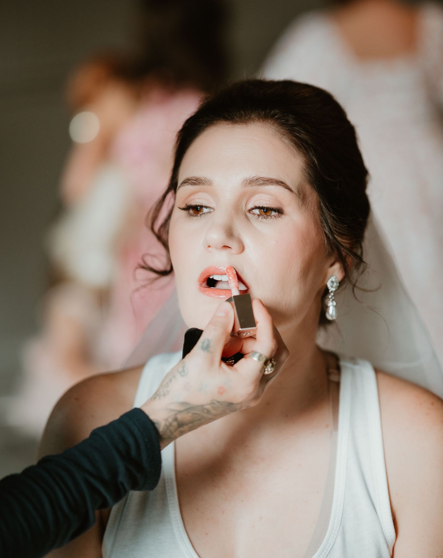 Makeup artist applying final touches during bridal preparation.