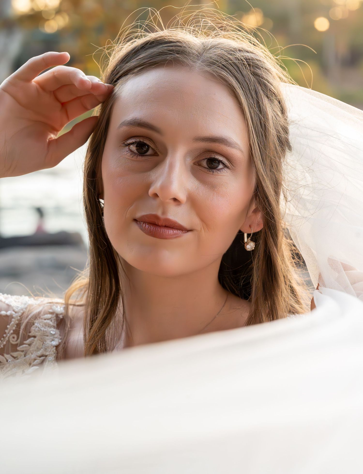 Close up portrait through sheer white veil creating a dreamy, romantic bridal photo effect.