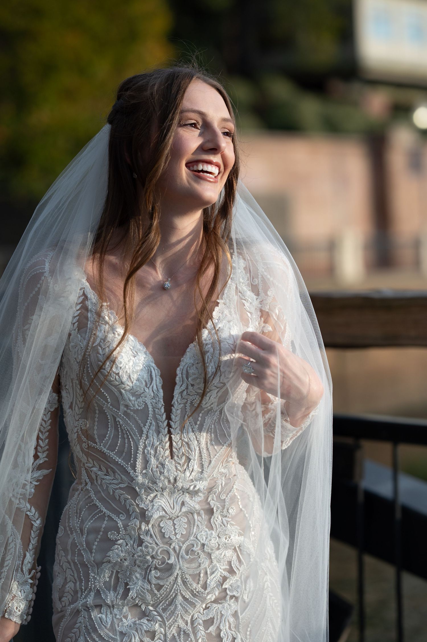 Candid bridal portraits showing joyful expressions and flowing veil in natural light.