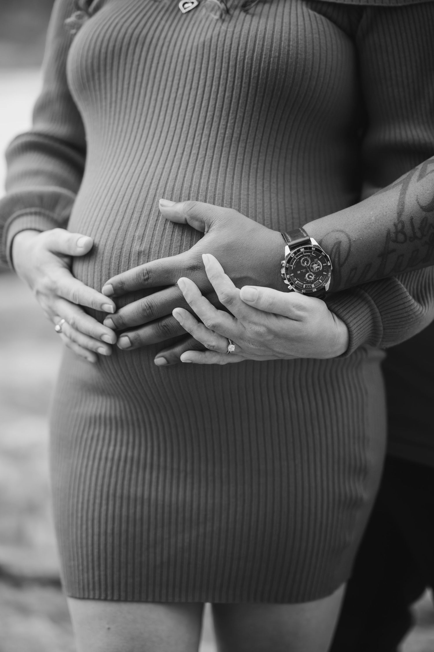 Close-up series of hands cradling pregnant belly in ribbed sweater.