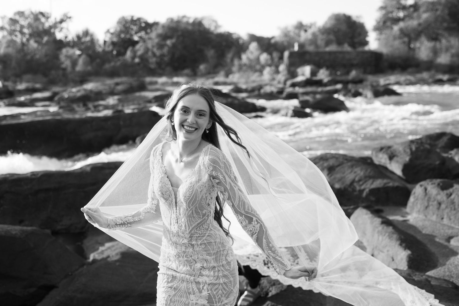 Romantic bridal scene with white dress and floating veil against natural rock formations.